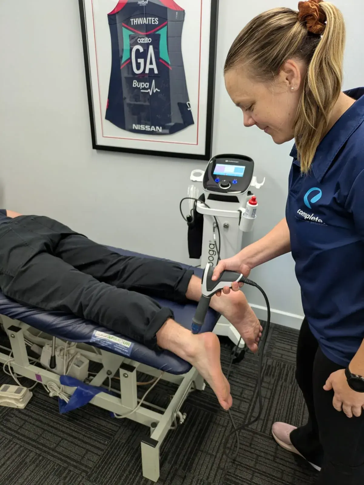 Physiotherapist performing shockwave therapy on a patient's Achilles at Complete Physio Richmond