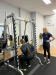 Supervised barbell squat during a strength training session at Complete Physio Richmond