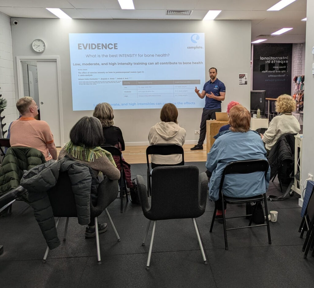 Physiotherapist presenting a bone health seminar on osteopenia and osteoporosis to a group of attendees