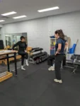 Physiotherapist guiding a patient through a balance exercise during post-operative rehabilitation