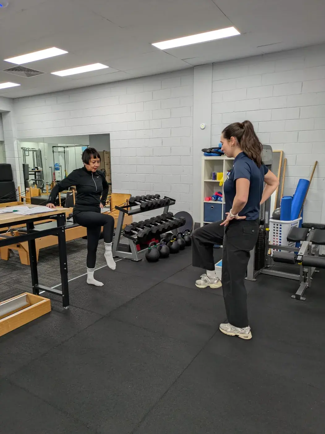 Physiotherapist guiding a patient through a balance exercise during post-operative rehabilitation