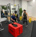 Client performing a trap bar deadlift under coaching supervision in the strength and conditioning gym at Complete Physio Richmond