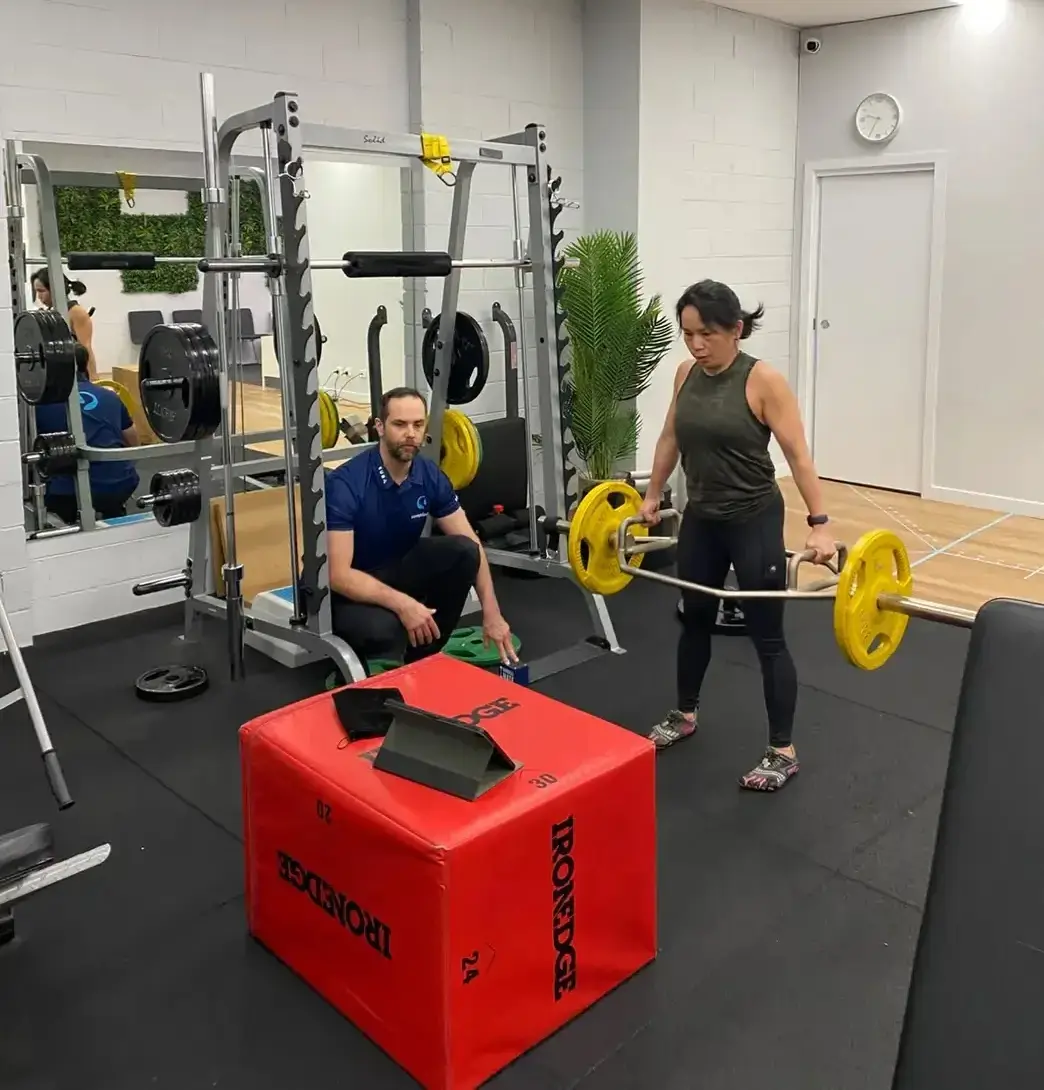 Client performing a trap bar deadlift under coaching supervision in the strength and conditioning gym at Complete Physio Richmond